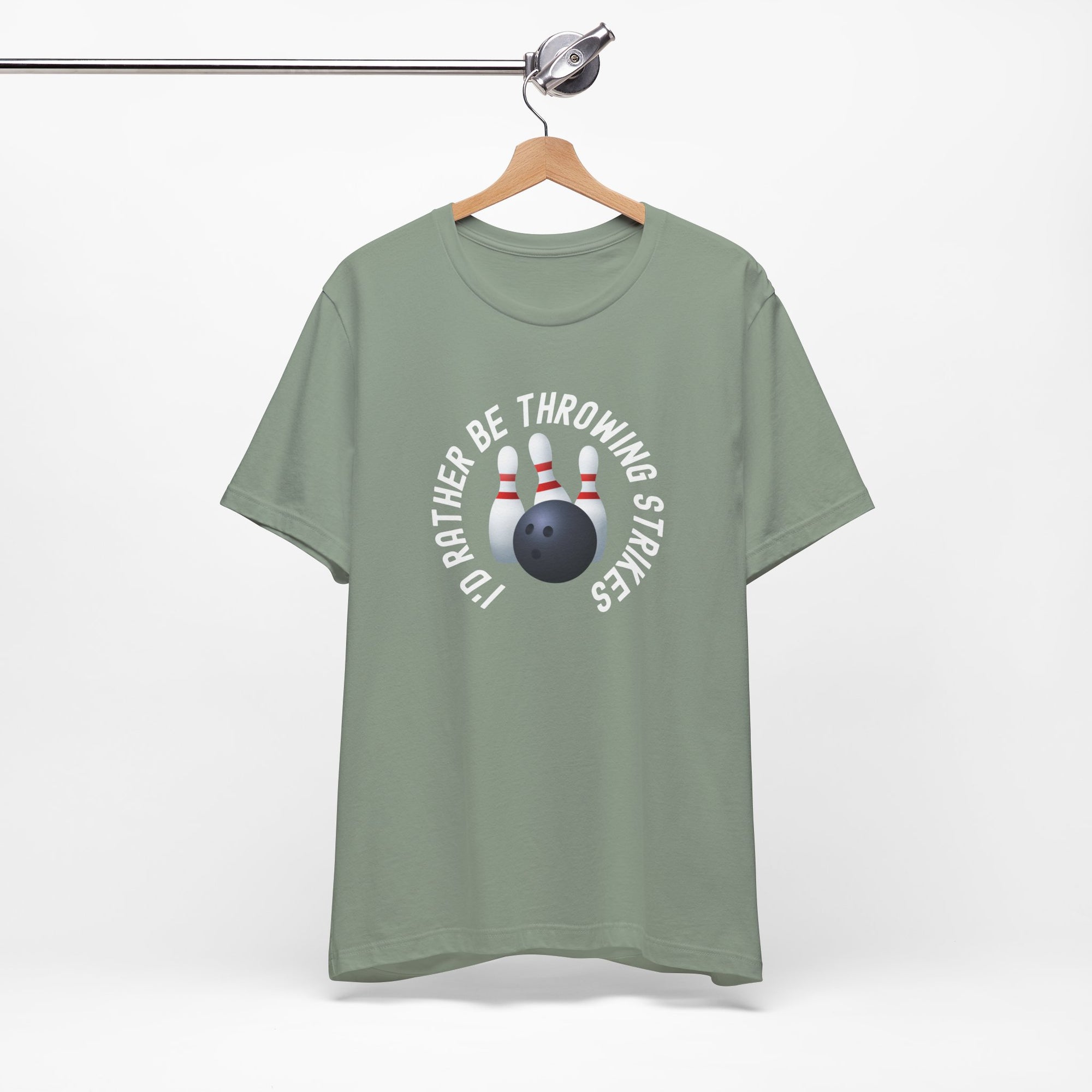 Light green t-shirt with bowling pins and a bowling ball and text saying "I'd Rather Be Throwing Strikes" on a hanger against a white background