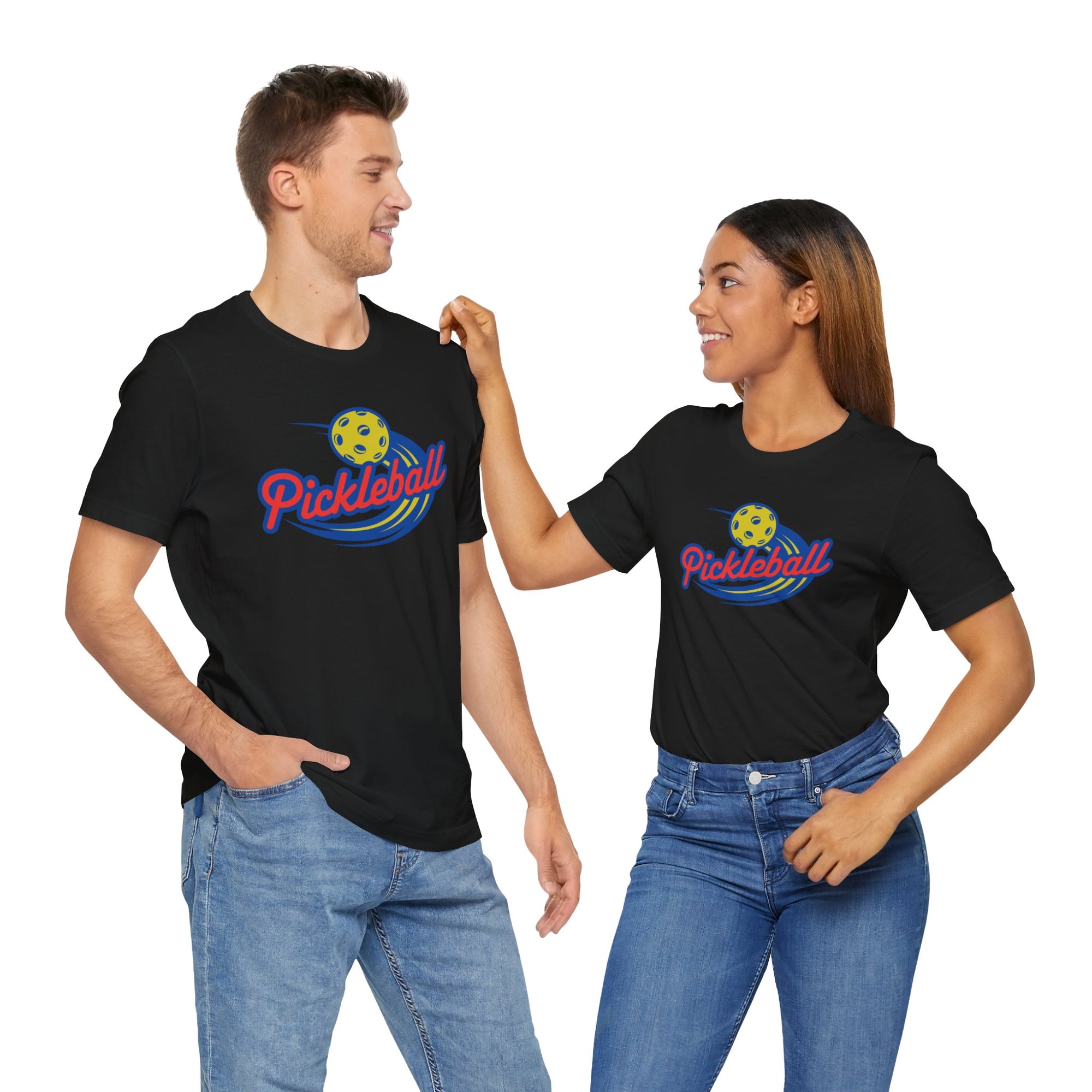 A man and a woman each wearing a black t-shirt with a classic pickleball logo featuring the word pickleball and a yellow pickleball with motion lines, on a hanger against a white background