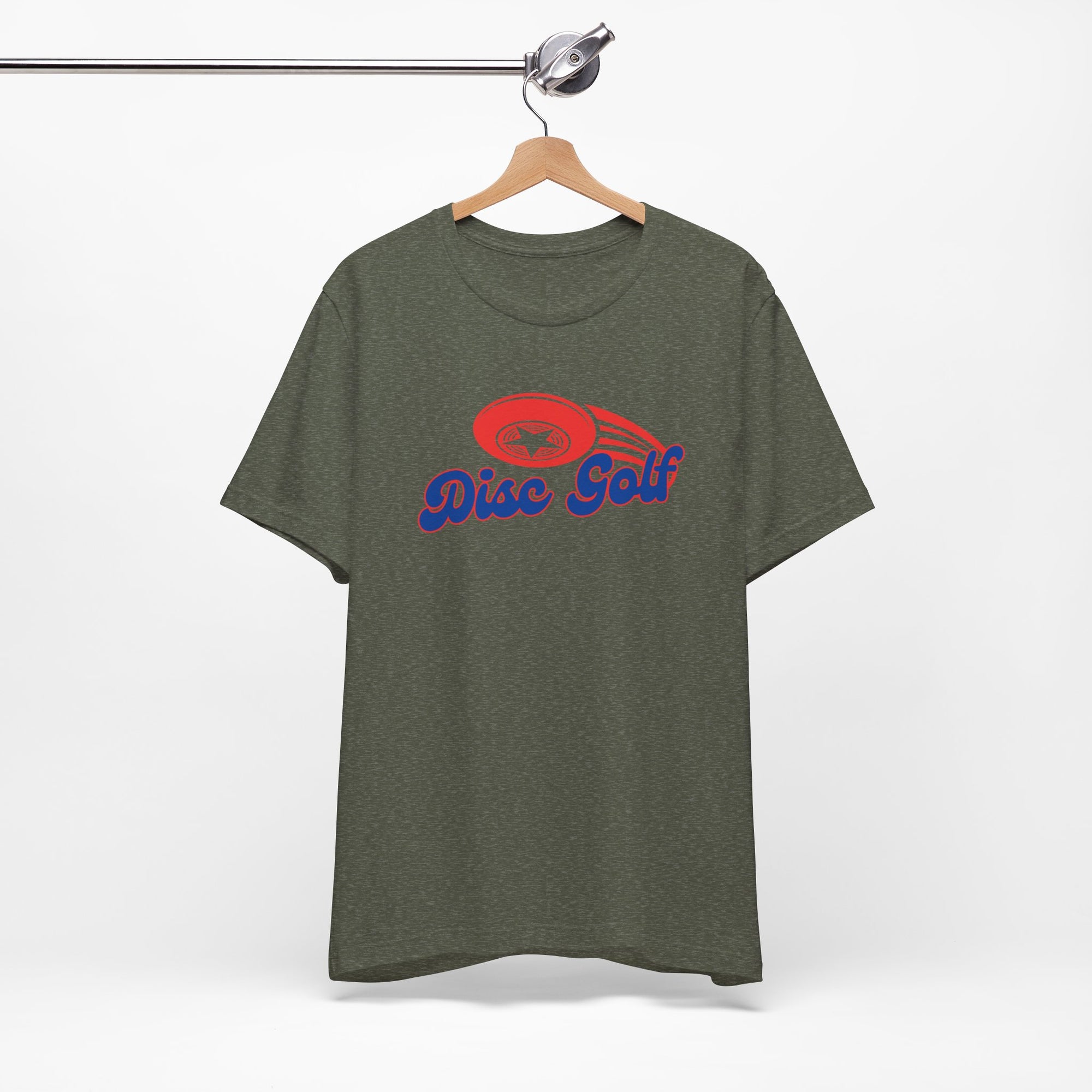 Military green t-shirt with 'Disc Golf' in a blue script text outlined in red and disc golf with motion trails, on a hanger against a white background