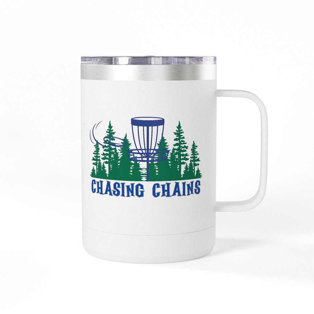 A white travel coffee tumbler mug with handle and lid with 'Chasing Chains' graphic featuring a flying disc golf disc and basket and chains in front of a scenic evergreen tree landscape, against a white background