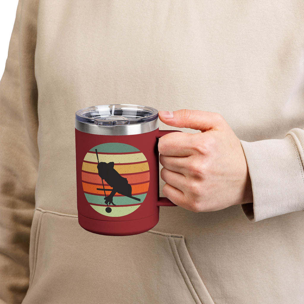 Person holding a maroon travel coffee mug with an image of a billiards player silhouette over a colorful retro graphic, on a white background