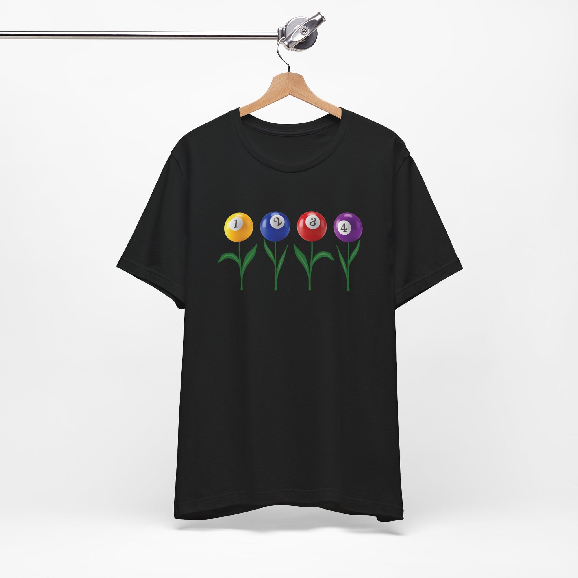 Black t-shirt with four colorful flowers made out of billiards balls with green stems, on a hanger against a white background