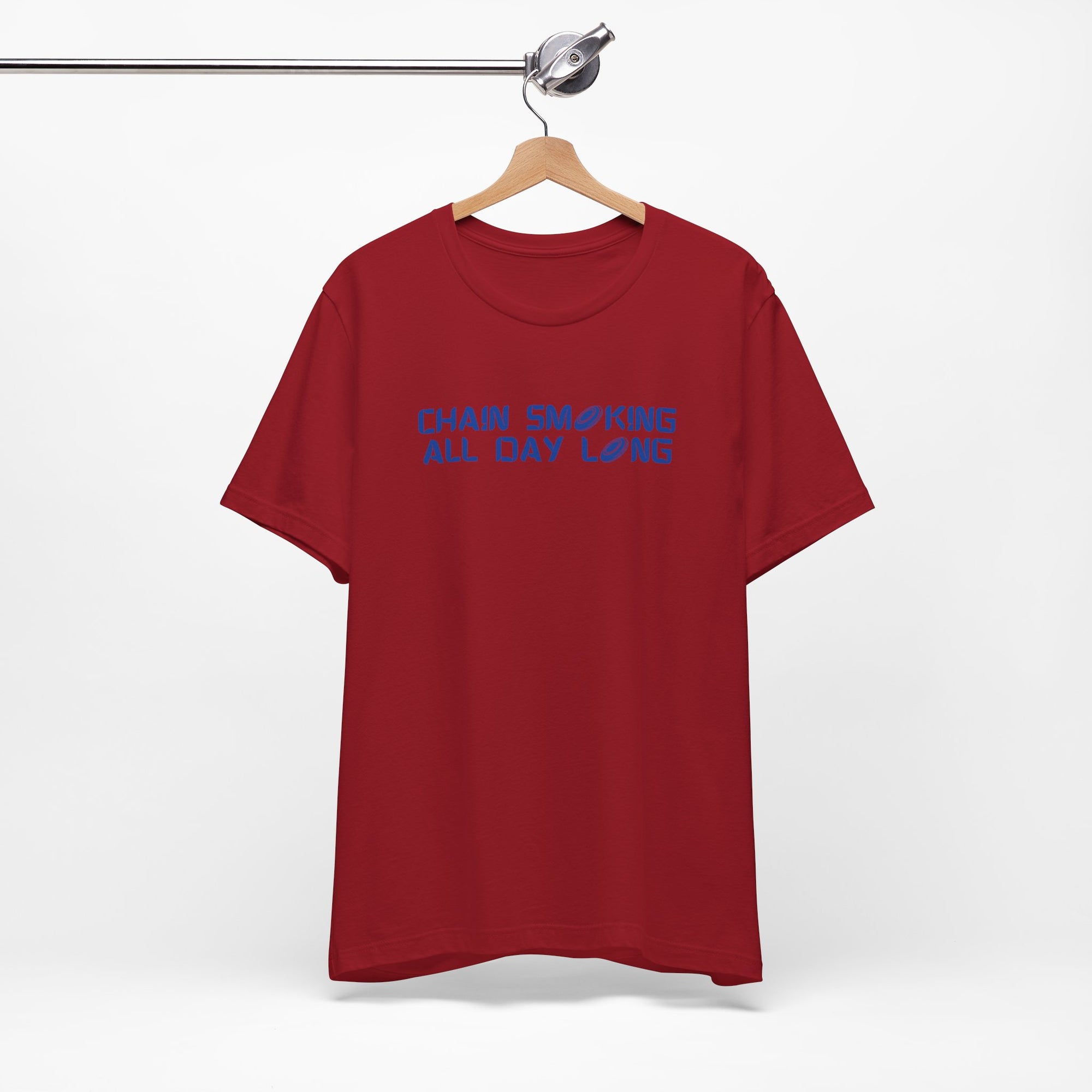 Maroon t-shirt with 'CHAIN SMOKING ALL DAY LONG' text with the O's replaced by disc golf discs, on a hanger against a white background