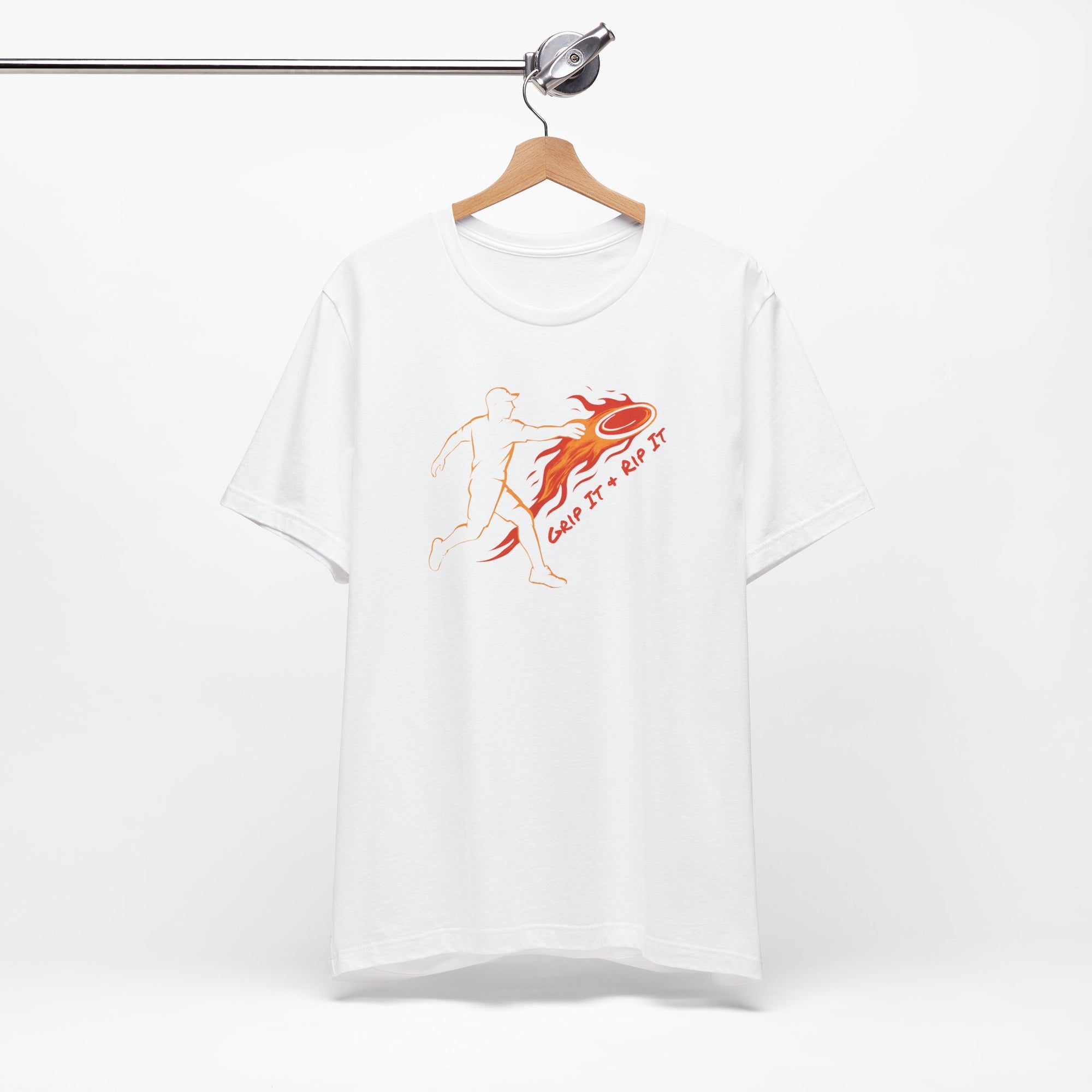 White t-shirt with a graphic design of a person throwing a disc golf disc with flames coming off the disc and text 'Grip It or Rip It' on a hanger against a white background.