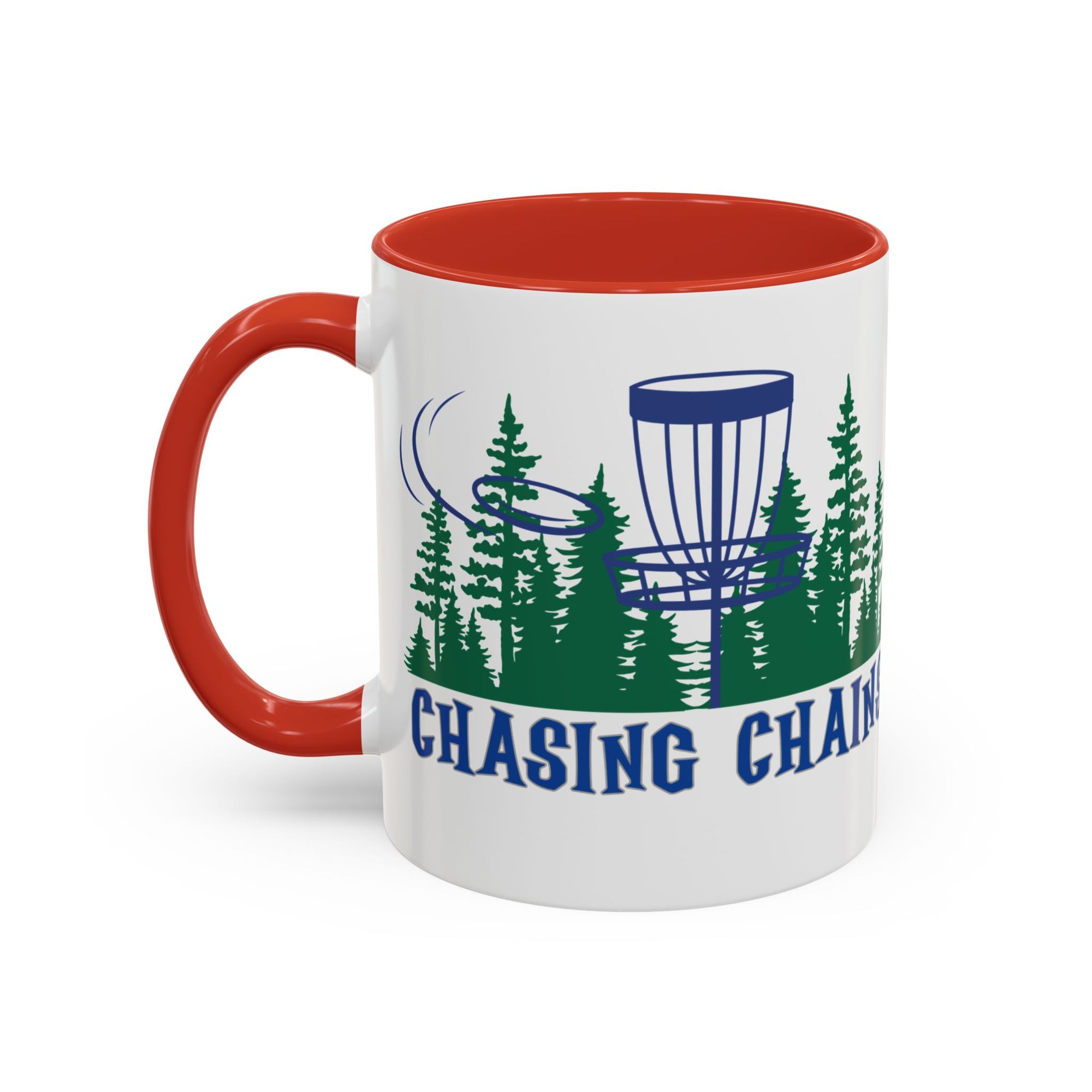 A ceramic coffee mug with red accents on the handle and interior, with 'Chasing Chains' graphic featuring a flying disc golf disc and basket and chains in front of a scenic evergreen tree landscape, against a white background