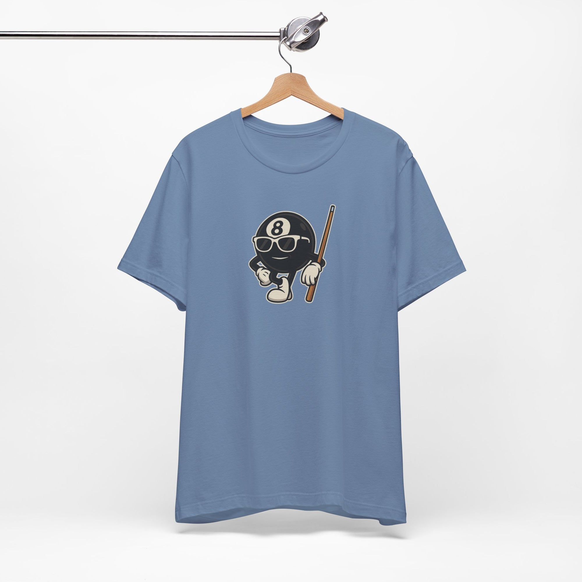 Steel blue t-shirt with a graphic of a cartoon billiards 8 ball with arms and legs and wearing sunglasses and leaning on a cue stick, on a hanger against a white background