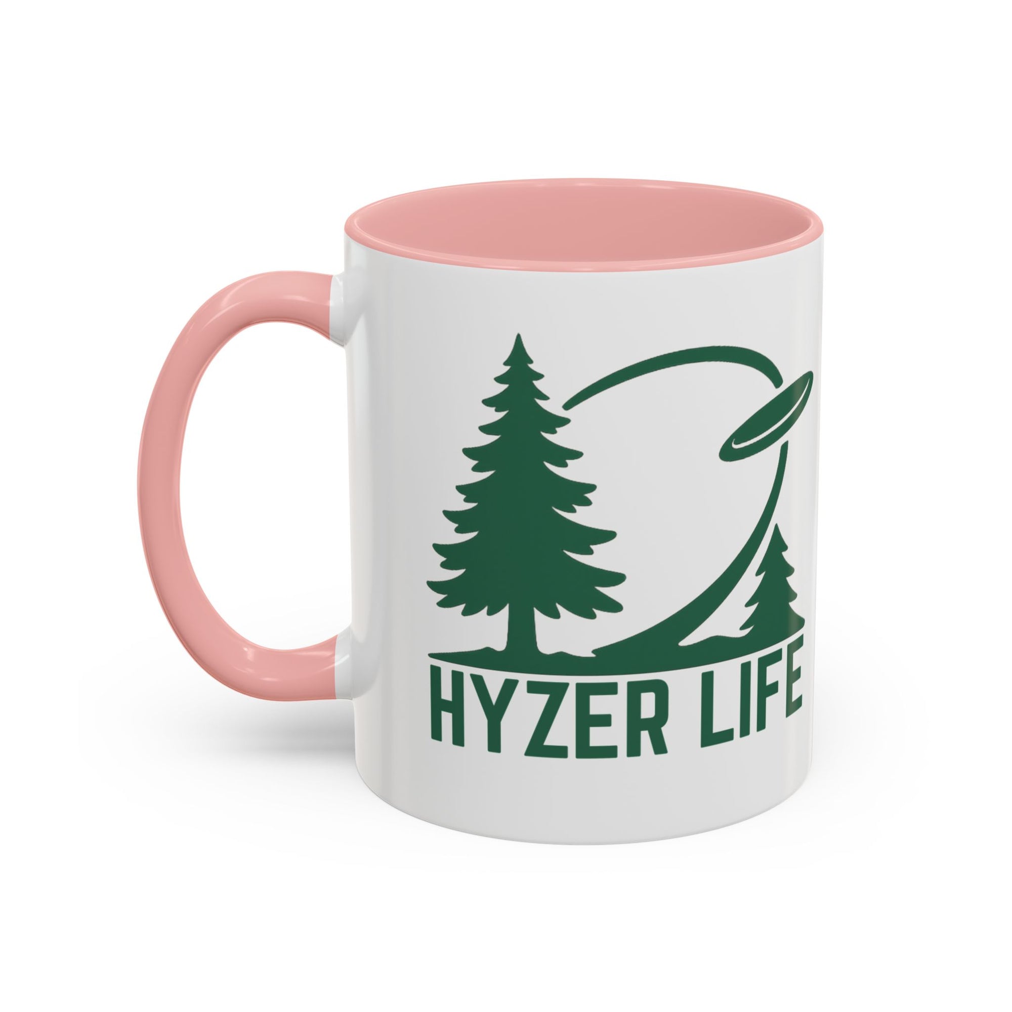 Ceramic coffee mug with pink accents on the handle and interior, with green graphic of trees and a disc golf flying with the words 'HYZER LIFE' below the image, against a white background