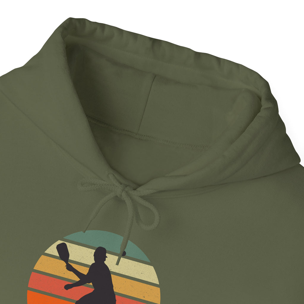 The necline of a green hoodiewith a graphic of a person playing pickleball over a colorful retro background