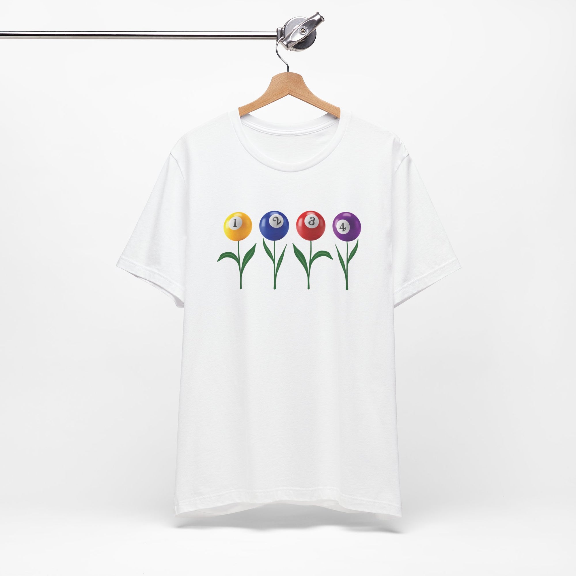 White t-shirt with four colorful flowers made out of billiards balls with green stems, on a hanger against a white background
