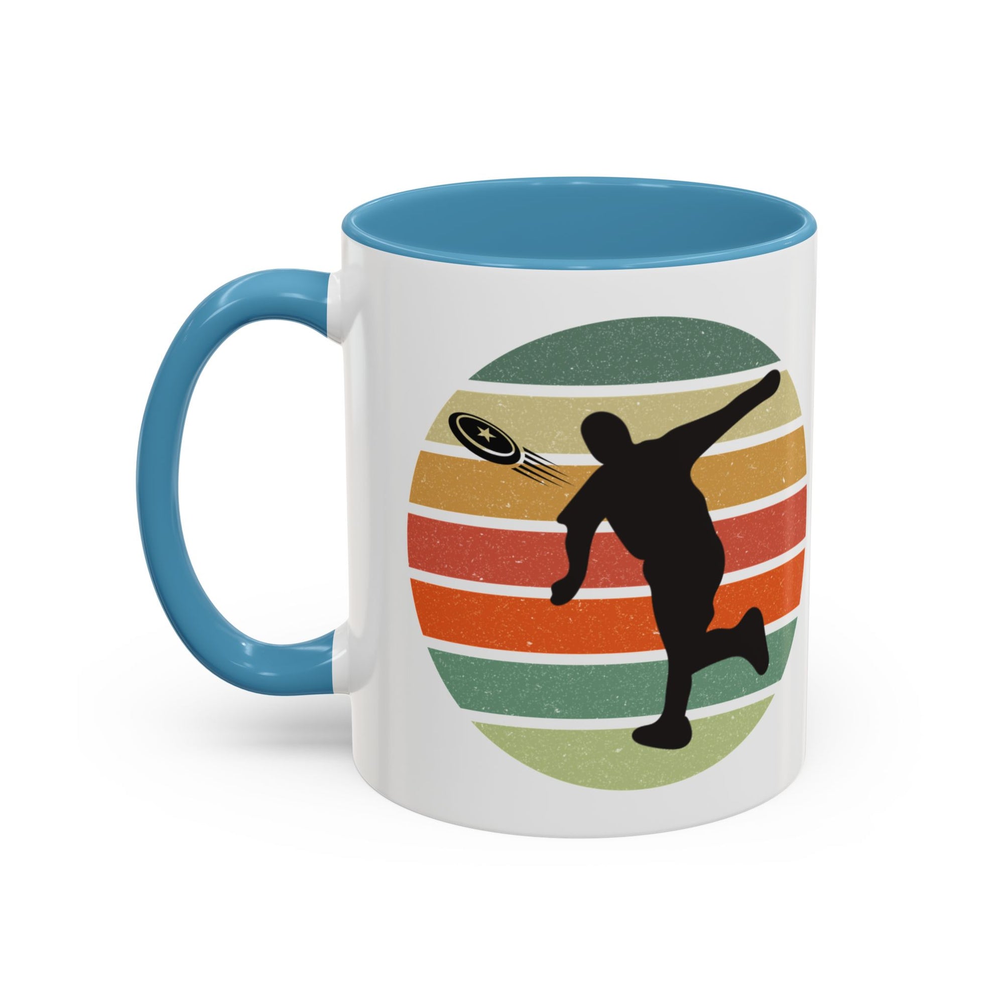 White ceramic coffee mug with light blue accents on the handle and inside. The mug features a graphic of a silhouette of a disc golf player above a colorful retro design.