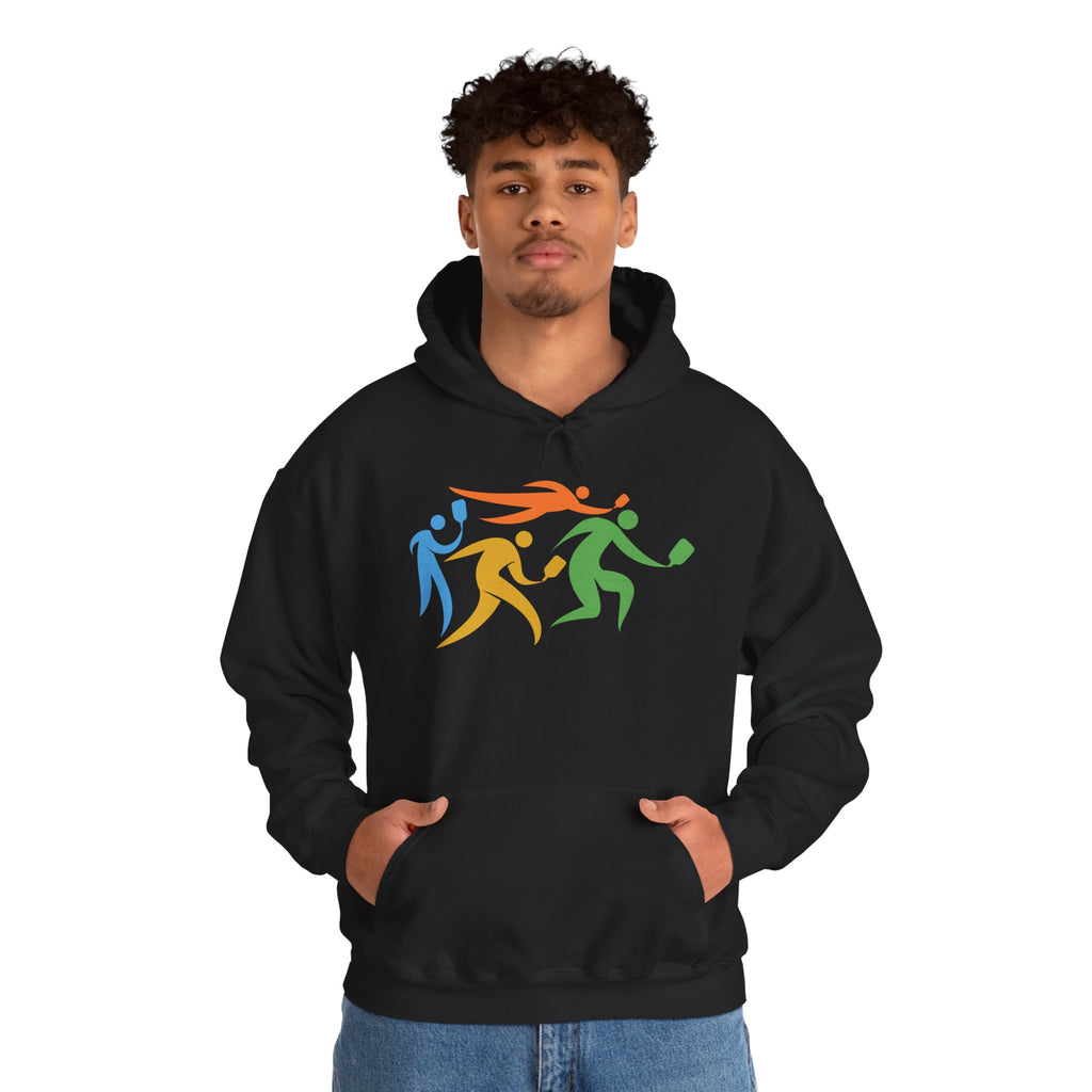 A man wearing a black hoodie featuring an image of four colorful pickleball player drawings playing pickleball against a white background
