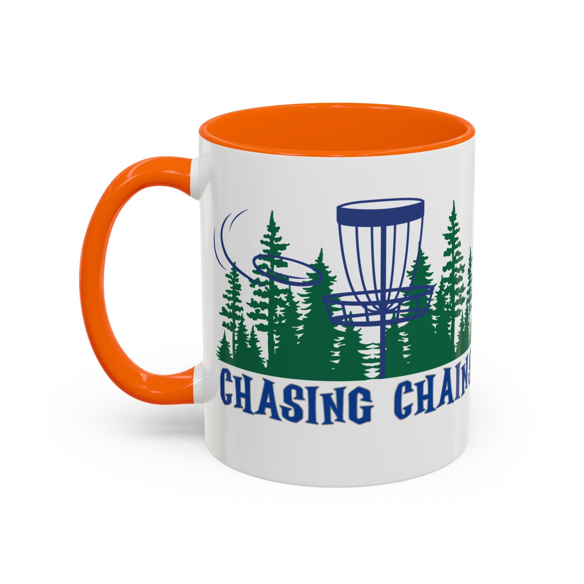 A ceramic coffee mug with orange accents on the handle and interior, with 'Chasing Chains' graphic featuring a flying disc golf disc and basket and chains in front of a scenic evergreen tree landscape, against a white background