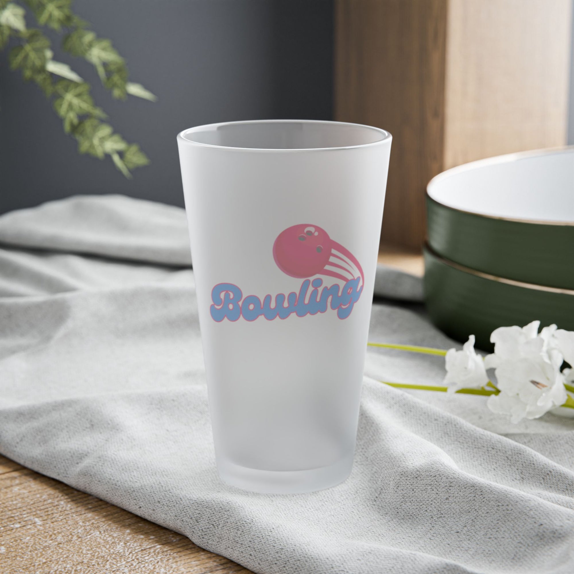 A frosted pint glass with a red bowling ball graphic and 'Bowling' text on a tabletop