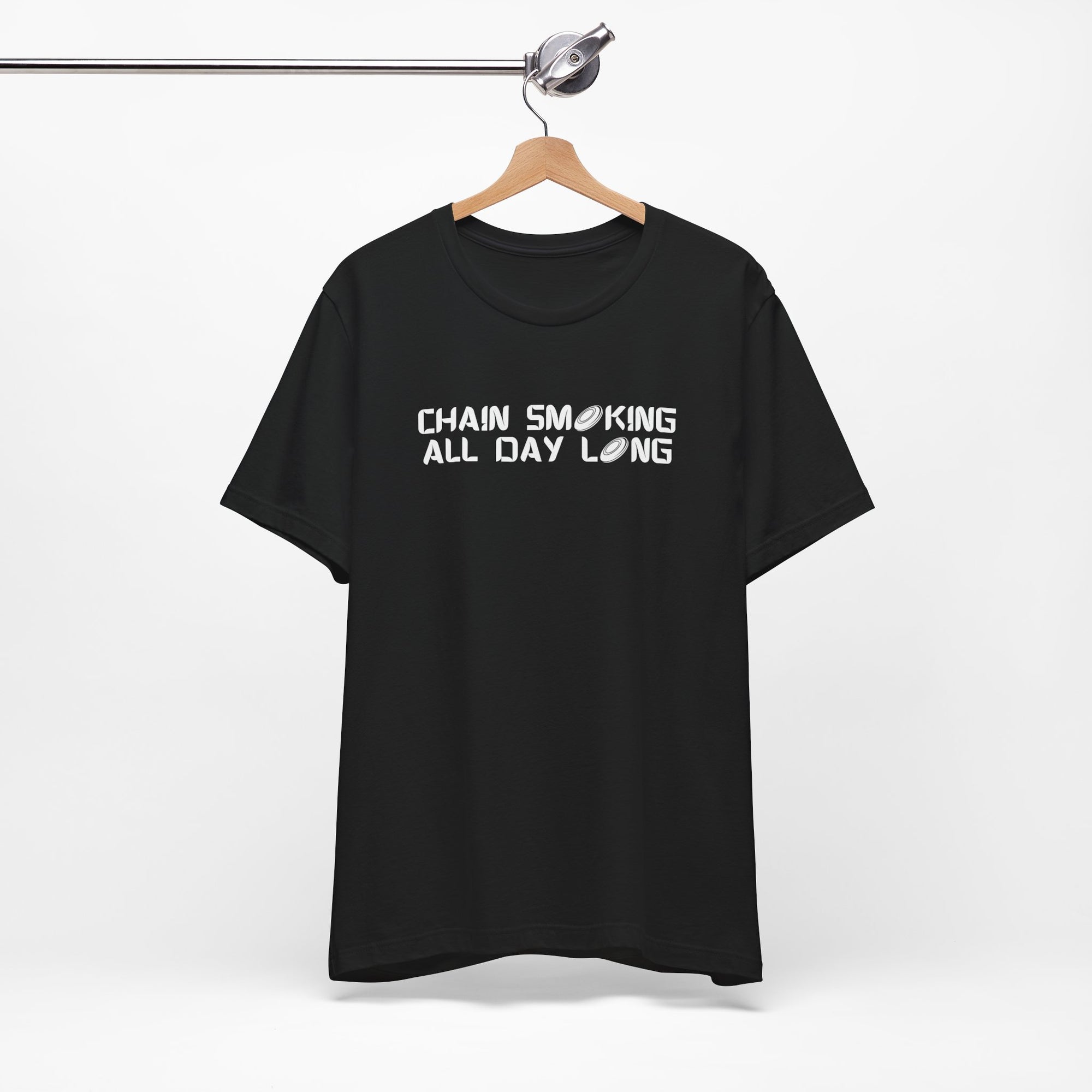Black t-shirt with 'CHAIN SMOKING ALL DAY LONG' text with the O's replaced by disc golf discs, on a hanger against a white background