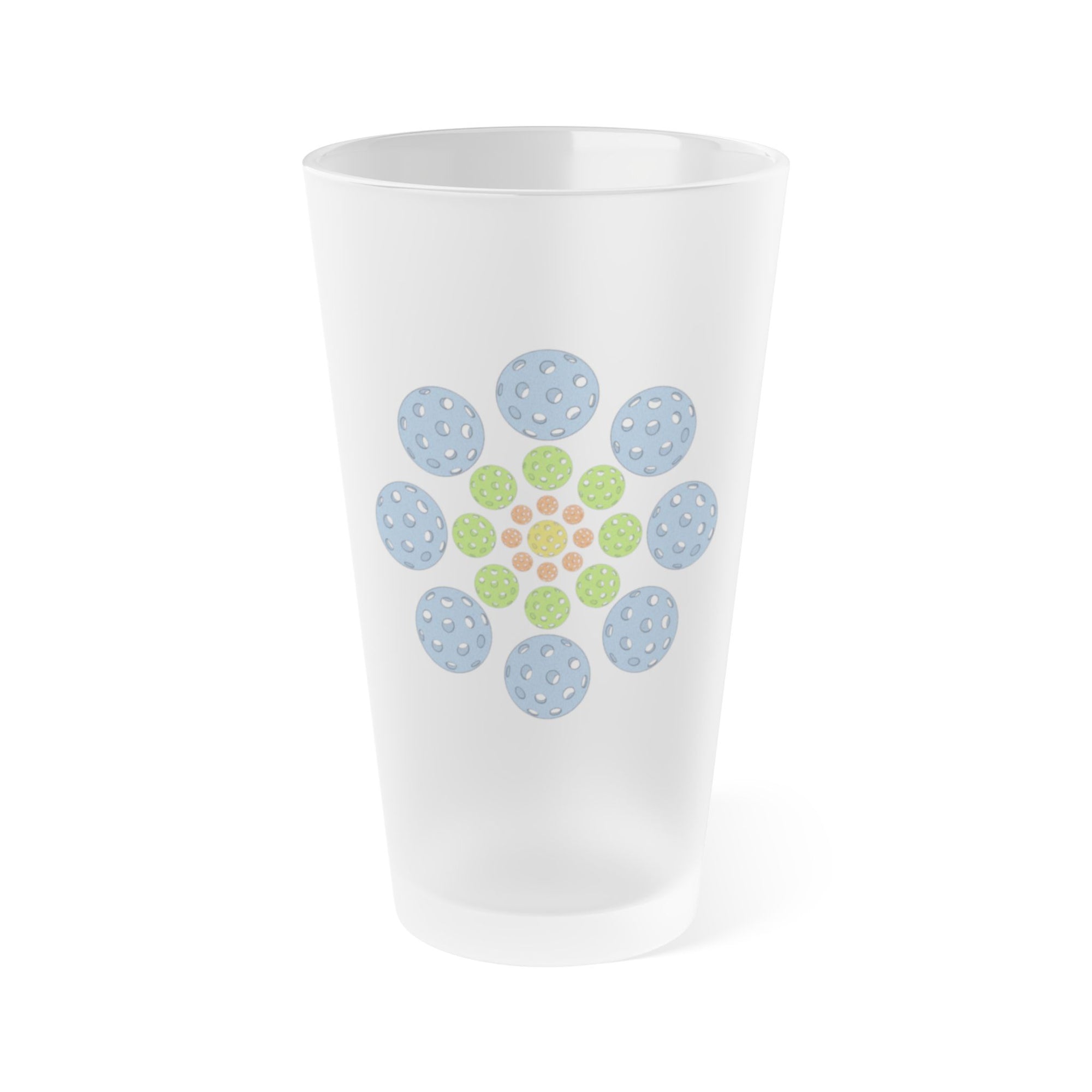 A frosted pint glass with colorful pickleballs in a circular pattern, on a white background