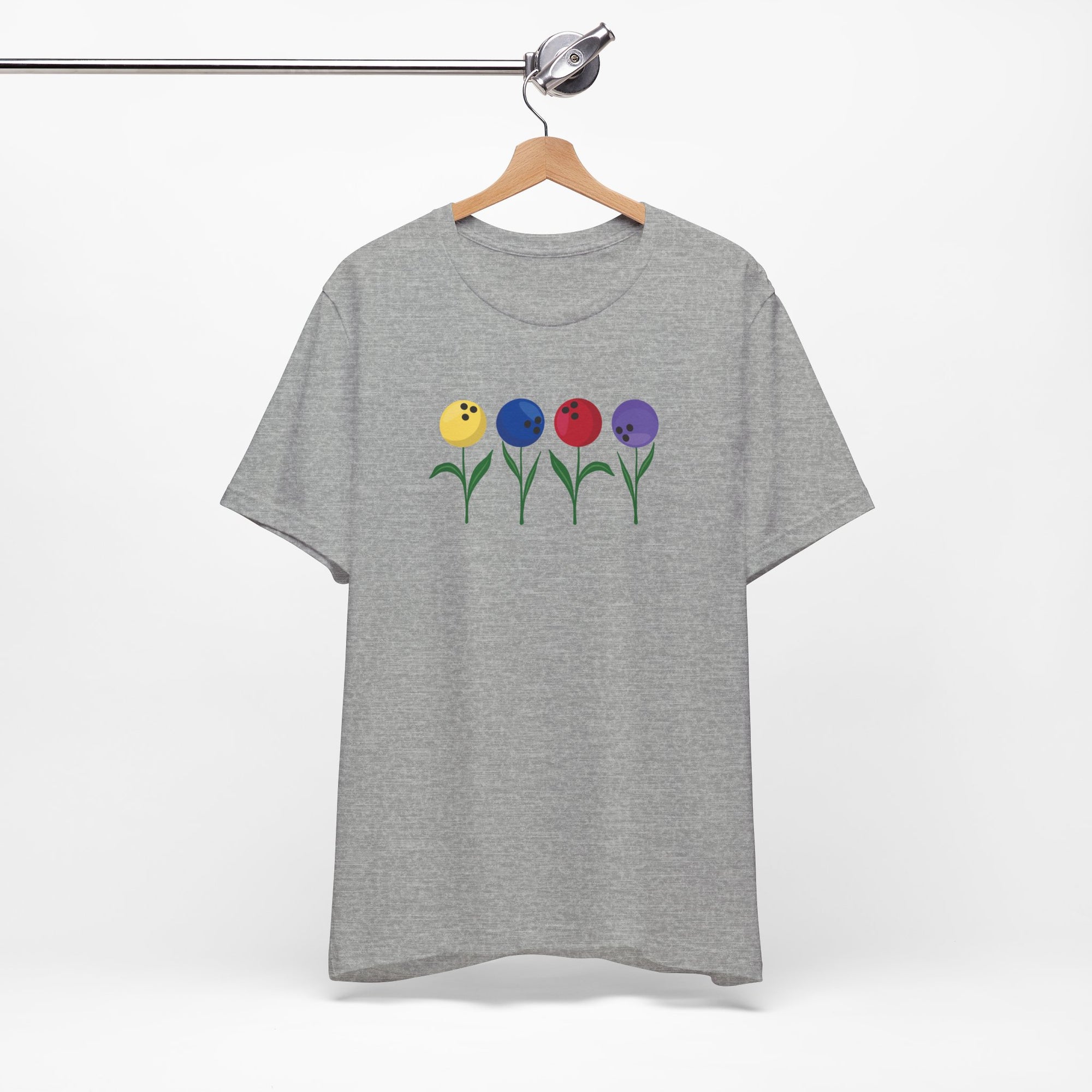 Gray t-shirt with colorful flowers made out of bowling balls, on a hanger against a white background