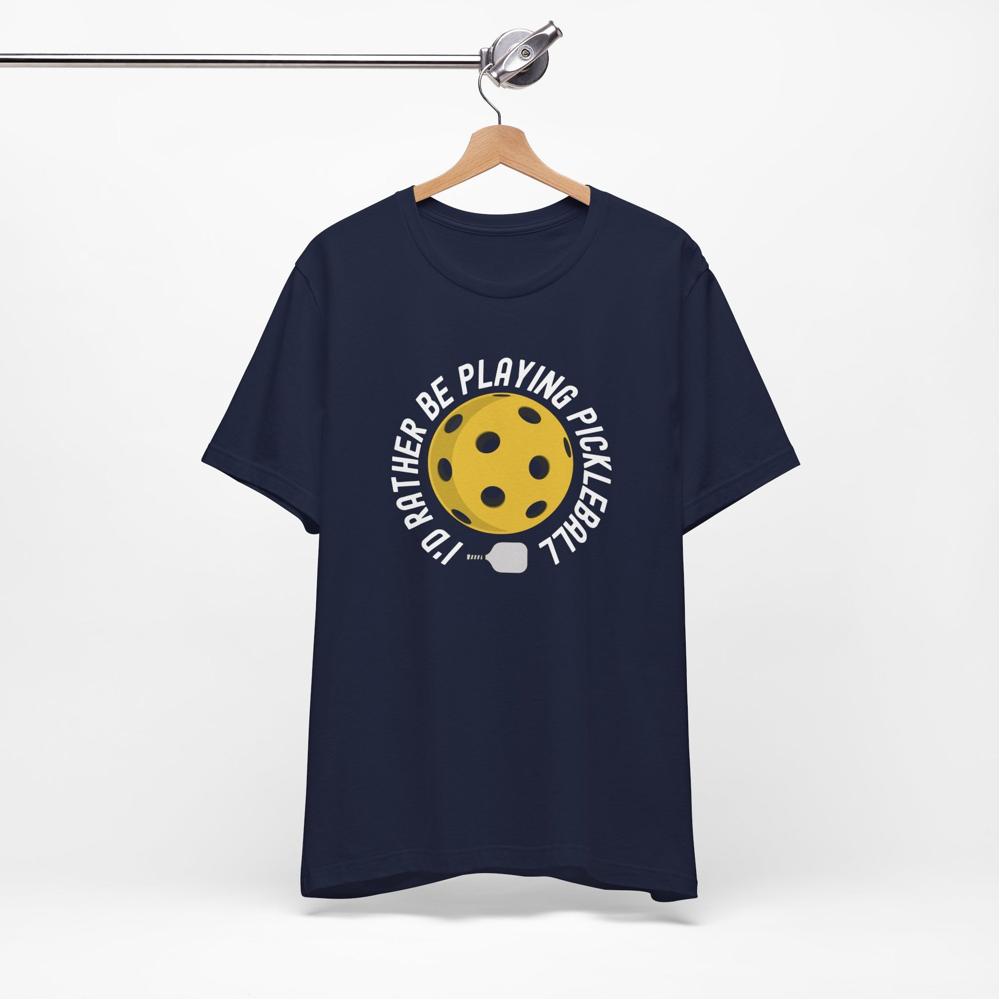 Navy blue t-shirt with a yellow pickleball and white pickleball paddle and the text "I'd Rather Be Playing Pickleball" on a hanger against a white background