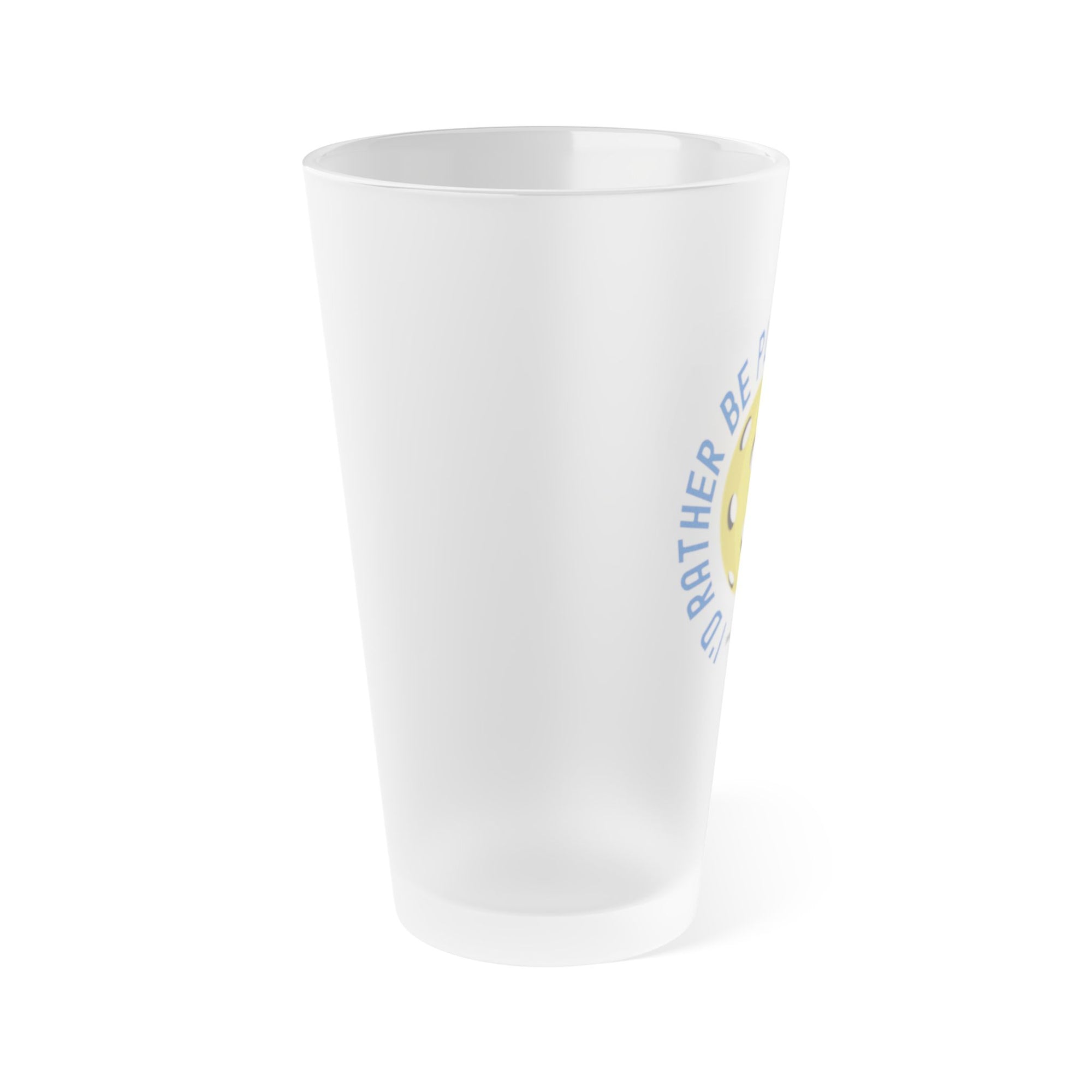 Side view of a frosted pint glass with the words "I'd Rather Be Playing Pickleball" surrounding a yellow pickleball and paddle, on a white background