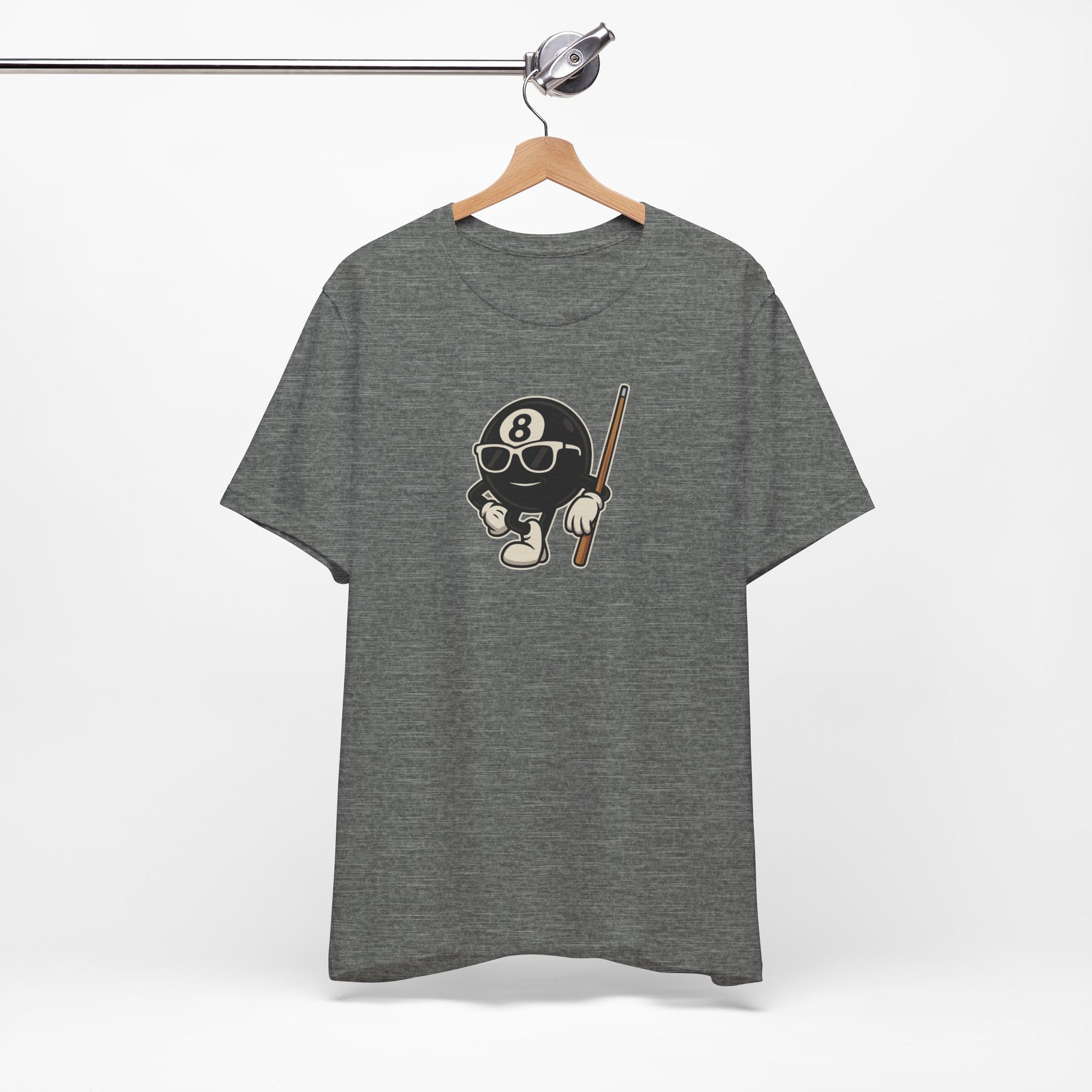 Gray t-shirt with a graphic of a cartoon billiards 8 ball with arms and legs and wearing sunglasses and leaning on a cue stick, on a hanger against a white background