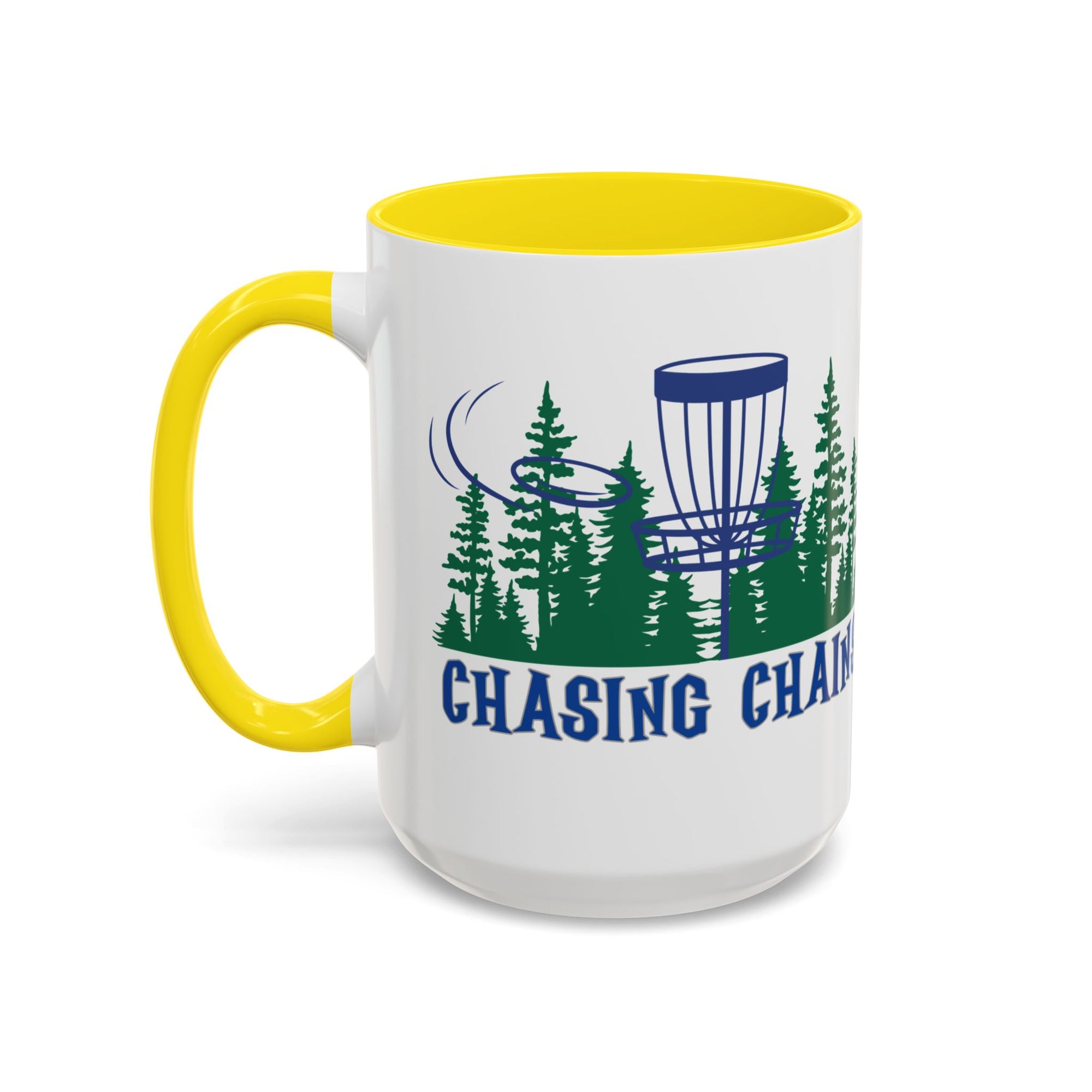 A ceramic coffee mug with yellow accents on the handle and interior, with 'Chasing Chains' graphic featuring a flying disc golf disc and basket and chains in front of a scenic evergreen tree landscape, against a white background