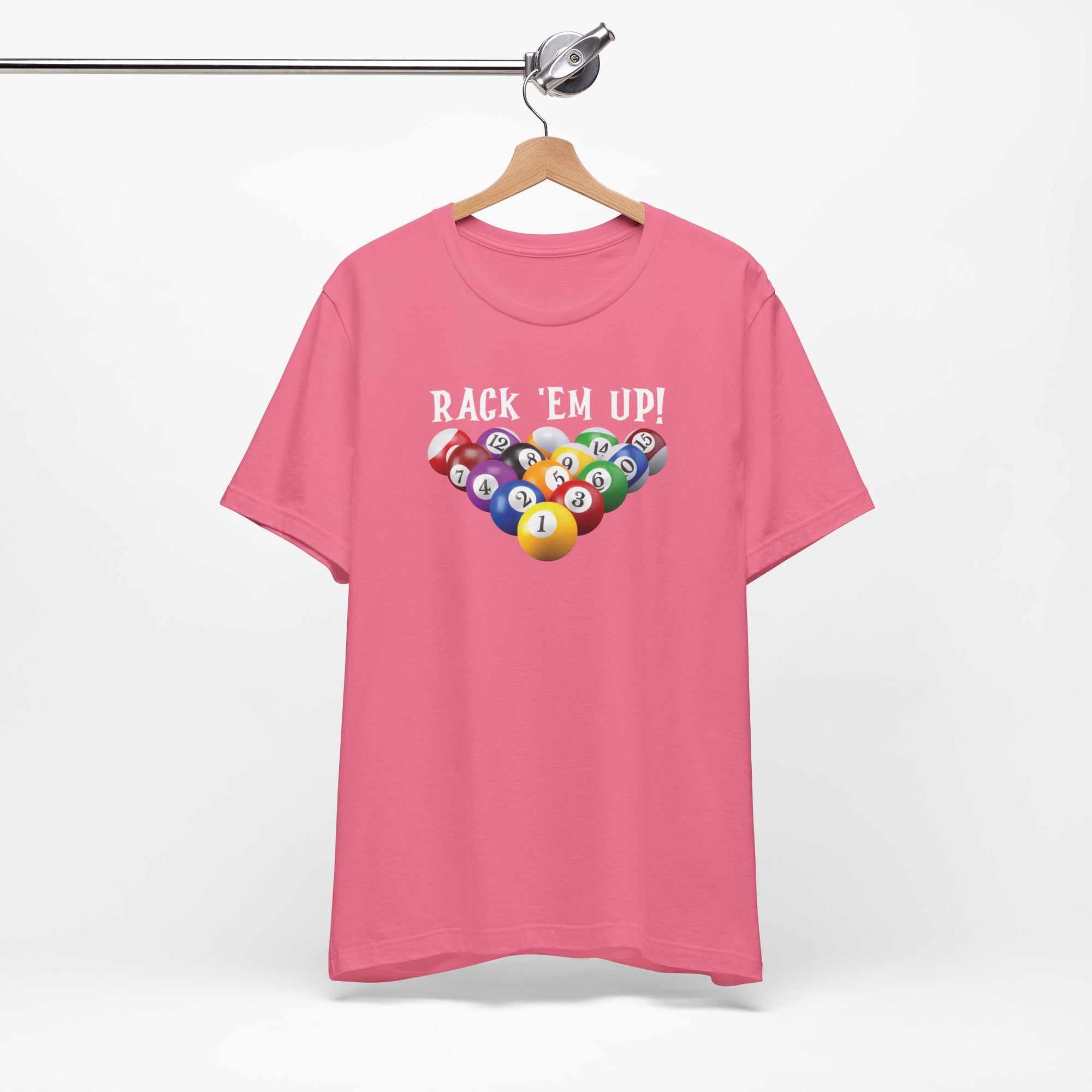 Pink t-shirt with racked pool ball design and 'Rack 'Em Up!' text, on a hanger against a white background